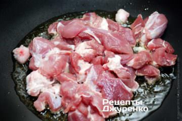 Выложить в разогретое масло кусочки мяса.